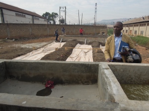 Abattoir manager Simon Lubega at the construction site in early January 2015 when the balloons were just starting to fill up. (ILRI/Kristina Roesel)